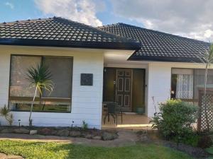 a small white house with a door and a patio at Boyle's Beach House - Fully furnished 3 Bedroom home. Secure parking. in Nambucca Heads