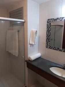 a bathroom with a sink and a shower and a mirror at Porto Carleto Temporadas - Quarto no Portobello Park Hotel in Porto Seguro