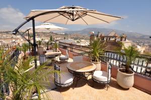 balcón con mesas, sillas y sombrilla en Riad Layla, en Fez