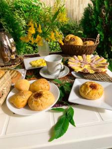 a table with plates of pastries and a cup of coffee at Pousada Barreirinhas House in Barreirinhas