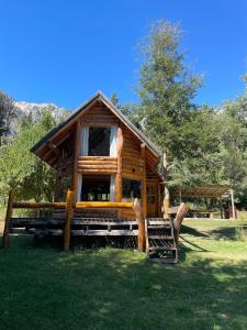 Cabaña de madera con una gran ventana en el césped en Cabaña Don Ramon - Puerto Patriada en El Hoyo