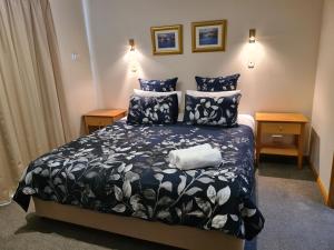 um quarto com uma cama preta e branca e duas mesas de cabeceira em DELANY VILLAS BRIGHT - Spa luxury on Delany Avenue em Bright