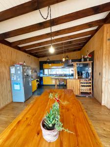 una cocina con una mesa de madera con una maceta. en Waiwen, en Pichilemu