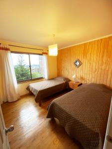 1 dormitorio con 2 camas y ventana en Waiwen, en Pichilemu