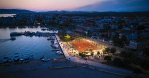 a city with a tennis court in the water at night at Apartment Sunshine in Srima
