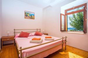 a bedroom with a bed with pink sheets and a window at House La Casa Simone in Jesenice +68 photos