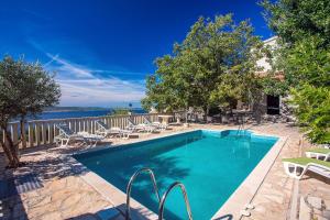 a swimming pool with chaise lounge chairs at House La Casa Simone in Jesenice