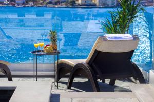 a chair and a table next to a swimming pool at Villa Lux in Vinišće