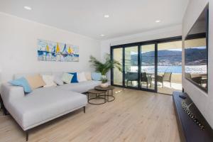 a living room with a white couch and a tv at Villa Lux in Vinišće