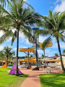 a playground with palm trees and a roller coaster at Porto Carleto Temporadas - Quarto no Portobello Park Hotel in Porto Seguro