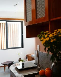 a kitchen with a counter with a vase of flowers at Laholm Hotel - Apartment in Nha Trang