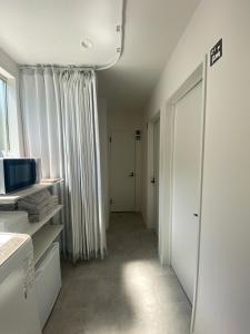 a room with a hallway with white walls and a window at Guest House DARUMA in Anan +36 photos