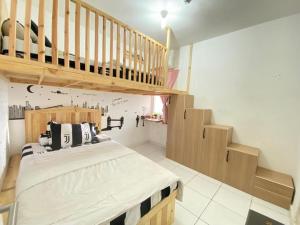 1 dormitorio con 1 cama grande y una escalera en Kuro House AT Aeropolis en Teko