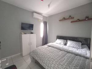um quarto com uma cama e um armário branco em Kuro House AT Aeropolis em Teko