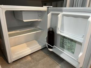 an open refrigerator with a bottle of sauce in it at Guest House DARUMA in Anan