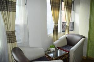 sala de estar con silla y ventana en Panoramic apartment in peaceful location of Thamel, en Katmandú