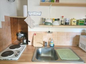 une cuisine avec un évier et une cuisinière dans l'établissement Charmant studio au Sauze pour 3 pers. avec balcon, box à ski et option ménage - FR-1-165A-171, à Enchastrayes