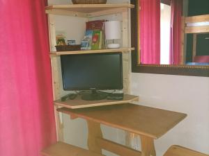 une télévision assise sur une étagère dans une pièce dans l'établissement Charmant studio au Sauze pour 3 pers. avec balcon, box à ski et option ménage - FR-1-165A-171, à Enchastrayes