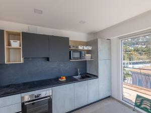 a kitchen with stainless steel appliances and a large window at Magnifique 3P climatisé en dernier étage avec terrasse face mer, proche centre Menton - FR-1-196-326 in Menton