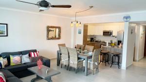 uma sala de estar com um sofá e uma mesa em Acogedor Apartamento a pasos de la playa caribeña Bavaro em Punta Cana