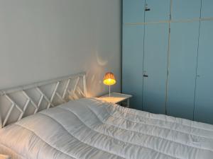 sypialnia z białym łóżkiem i lampką w obiekcie Appartement 3 pièces avec terrasses et vue mer - Parking inclus - FR-1-487-349 w mieście Cabourg