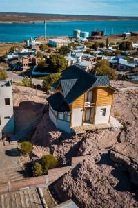 a small house on a hill next to the ocean at Cabañas Las Nubes in Puerto Deseado