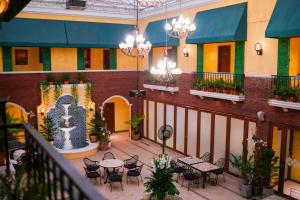 an indoor patio with tables and chairs and chandeliers at The Pepperland Hotel in Legazpi