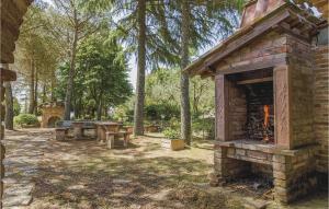 a stone fireplace in a park with picnic tables and trees at Scaterina in Monte San Savino