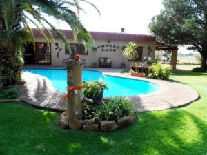 a swimming pool in front of a house at A Cherry Lane Self Catering and B&B in Bloemfontein