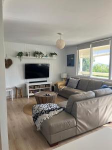 a living room with a couch and a flat screen tv at Aldinga Beach Break - C21 SouthCoast Holidays in Aldinga Beach