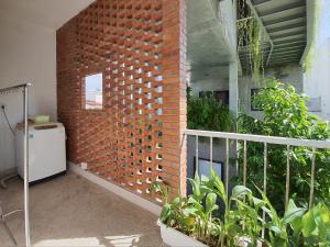 a room with a brick wall and a balcony with plants at Green Peace Village in Da Nang