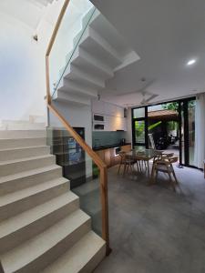 a staircase in a house with a table and chairs at Green Peace Village in Da Nang