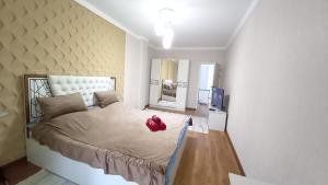 ein Schlafzimmer mit einem Bett, auf dem ein Teddybär liegt in der Unterkunft 2х комнатная квартира в ЖК Отау сити in Schymkent