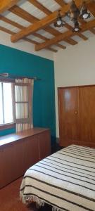 ein Schlafzimmer mit einem Bett und einer blauen Wand in der Unterkunft Casa Alma Verde calma in Luyaba