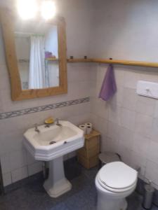 ein Badezimmer mit Waschbecken, Toilette und Spiegel in der Unterkunft Casa Alma Verde calma in Luyaba