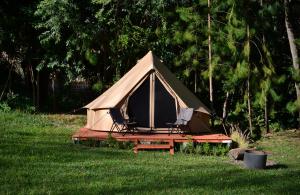 a tent with a table and chairs in the grass at Cocuyo Glamping in San Agustín Etla