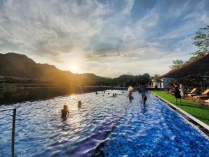 un grupo de personas nadando en un lago en Wyndham Grand Vedana Ninh Binh Resort en Ninh Binh