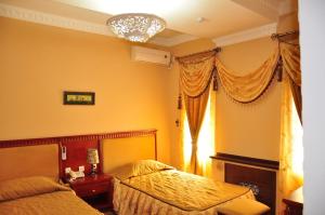 um quarto com 2 camas e uma janela em Sarbon Plaza Hotel em Bukhara