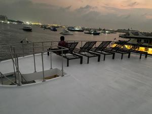 a person sitting on the deck of a boat at Zaa Queen in Male City