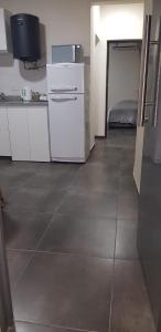 uma cozinha com armários brancos e piso em azulejo em Dpto Falucho em San Luis