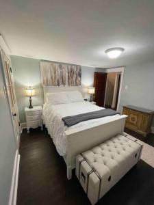 una camera con un grande letto bianco e uno sgabello di River House a South Williamsport