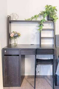 a desk with a vase of flowers and a shelf at 1 Private Double Room in Berala near Station close to Olympic Park in Regents Park