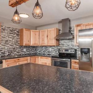 a kitchen with wooden cabinets and a black counter top at Spacious 3 BD Close To Everything! You’ll Love It! in Anchorage