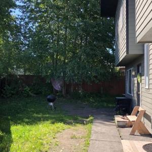 a grill in a yard next to a house at Spacious 3 BD Close To Everything! You’ll Love It! in Anchorage