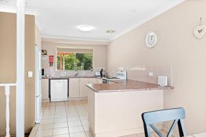 a kitchen with white appliances and a counter top at 28 Nioka Street in Dalmeny