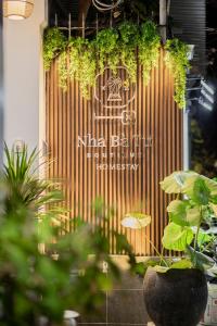 a wooden door with a sign on it with plants at Nhà Bà Tư Boutique Homestay in Vung Tau