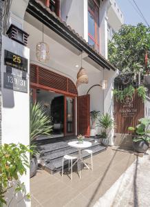 a patio with a table and chairs in front of a building at Nhà Bà Tư Boutique Homestay in Vung Tau