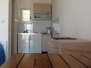 a kitchen with a stainless steel refrigerator and wooden floors at Villa Mirista in Luštica