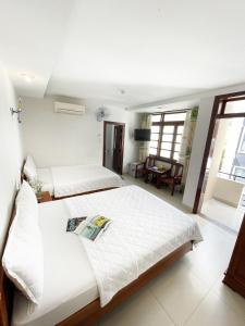 een slaapkamer met 2 bedden en een woonkamer bij Khách sạn Nắng Biển - Sunny Sea in Nha Trang