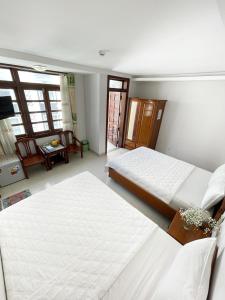 een slaapkamer met 2 bedden en een woonkamer bij Khách sạn Nắng Biển - Sunny Sea in Nha Trang